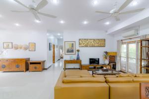 a living room with couches and a ceiling fan at Bangsaphan Paradise Bankrut Vanilla Villa in Ban Krut