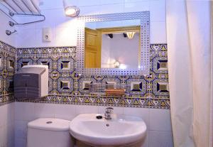 y baño con lavabo, aseo y espejo. en Hostal Lis en Sevilla