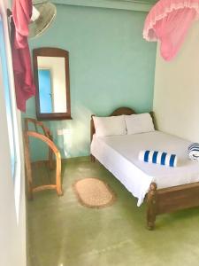 Dormitorio pequeño con cama y espejo en Bayview Seafood rest, en Weligama