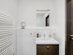 a white bathroom with a sink and a mirror at limehome Mönchengladbach Fliethstraße in Mönchengladbach
