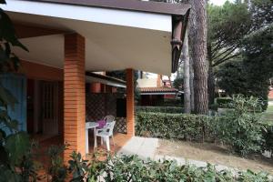 a porch of a house with a table and a chair at Villaggio Euro Residence Club in Bibione +18 photos