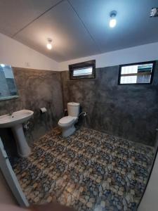 a bathroom with a toilet and a sink at Abinu"s Place in Dickwella