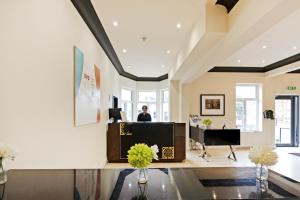 a man sitting at a desk in a living room at OYO The Baltimore Hotel in Middlesbrough