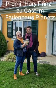 un hombre y una mujer parados frente a una casa en Ferienhaus Planetz, en Kaindorf