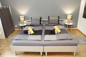 1 Schlafzimmer mit 2 Betten und gelben Kissen in der Unterkunft Pension Breite in Basel