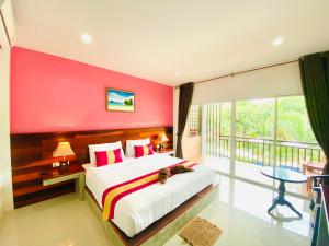 a bedroom with a large bed with a red wall at Hatzanda Lanta Resort - SHA Extra Plus in Ko Lanta