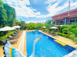 a swan in the water next to a swimming pool at Hatzanda Lanta Resort - SHA Extra Plus in Ko Lanta