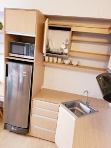 a small kitchen with a sink and a refrigerator at Steff's Condo 1805 at Centrio Tower in Cagayan de Oro