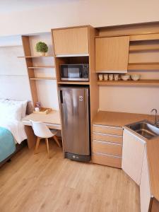 a kitchen with a refrigerator and a desk and a bed at Steff's Condo 1805 at Centrio Tower in Cagayan de Oro