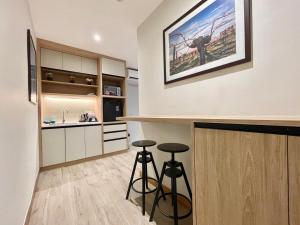 a kitchen with two bar stools and a counter at LV Modern Suite Langkawi by Zervin in Kuah