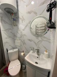 a bathroom with a toilet and a sink and a mirror at Lightroom in Kharkiv +7 photos