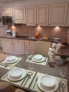 a kitchen with a table with white plates and silverware at W3 Haus Ganghofer in Leutasch