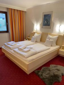 ein Schlafzimmer mit einem großen Bett mit weißer Bettwäsche und Kissen in der Unterkunft W3 Haus Ganghofer in Leutasch