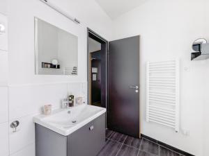 a white bathroom with a sink and a mirror at Limehome Mönchengladbach Fliethstraße in Mönchengladbach +42 photos