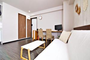 a hotel room with a bed and a dining table at TOMMY CONDOMINIUM WAKASA 502 in Naha