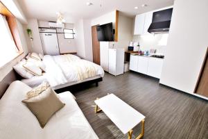 a small room with a bed and a kitchen at TOMMY CONDOMINIUM WAKASA 502 in Naha