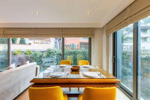 une salle à manger avec une table et des chaises jaunes dans l'établissement Phenomenal Apartment in Ortakoy, Besiktas, à Istanbul