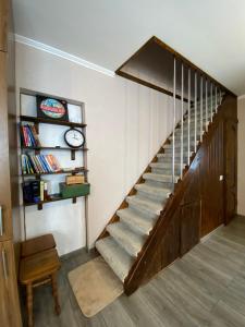 a staircase in a room with a book shelf and a clock at Смарт-квартира in Skole