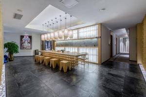 uma grande sala de jantar com uma mesa longa e cadeiras em One House em Shenzhen