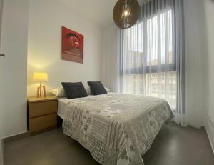 sypialnia z łóżkiem i dużym oknem w obiekcie Calpe Beach Sea View w mieście Calpe