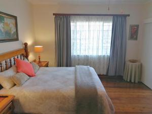 um quarto com uma cama grande e uma janela em Fairbairn Guest Farm em Maclear