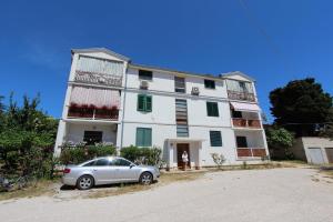 un coche aparcado delante de un edificio blanco en Apartment Dina, en Rovinj