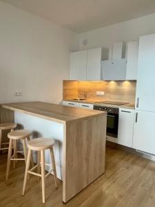 a kitchen with a counter and stools in it at A Nice Place to Stay Apartments in Prague