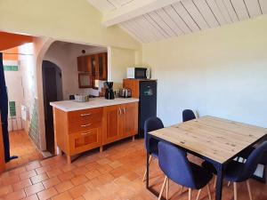 a kitchen with a wooden table and a table and chairs at Villa d'une chambre avec piscine privee jacuzzi et jardin amenage a Saint Georges de Luzencon in Saint-Georges-de-Luzençon