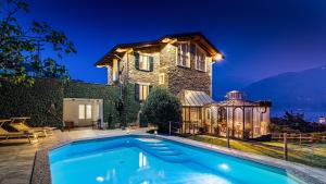 eine Villa mit einem Pool vor einem Haus in der Unterkunft Villa La Dolce 8, Emma Villas in San Siro