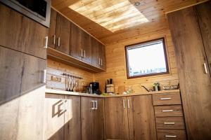 una cocina con armarios de madera y una ventana en Houseboat Bonanza Prague en Praga