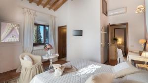 Biała sypialnia z łóżkiem, krzesłem i biurkiem w obiekcie Villa Beltramonto 14, Emma Villas w mieście Pomarance