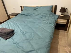 a large bed with a blue comforter on it at Apartament centrul vechi in Baia Mare