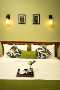 a hotel room with a bed with a tray on it at The Golden Tusk By Ivory Destinations in Rāmnagar