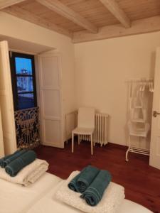 a room with two towels on a bed and a chair at NAMOR-Apartamento Tres Balcones in Ribadeo