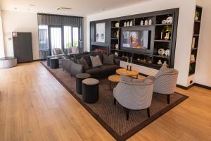 a living room with a couch and tables and chairs at Gr8 Hotel Sevenum in Sevenum +21 photos