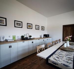 a kitchen with white cabinets and a table and chairs at Apartmány Rožmberk in Rožmberk nad Vltavou