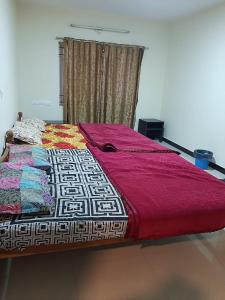 a bed in a room with a red blanket on it at jack N jill holidays inn in Ooty