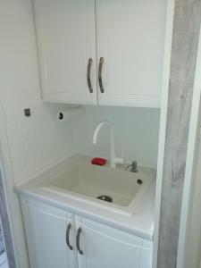 - Baño con lavabo blanco y armarios blancos en Apartament Skawina, en Skawina