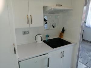 a kitchen with white cabinets and a black sink at Apartament Skawina in Skawina +12 photos