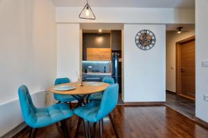 comedor con mesa de madera y sillas azules en Apartman 41 en Zlatibor