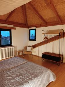 um quarto com uma cama e duas janelas em NAMOR - Atico Zen em Ribadeo