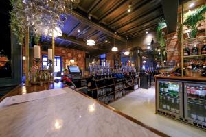 a bar with a large wooden counter in a room at Governors House by Greene King Inns in Cheadle Hulme