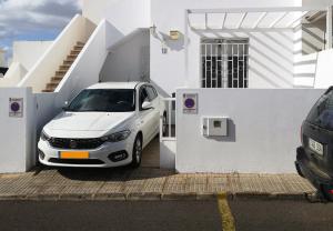 a white car parked in front of a white house at Casa Donna in Playa Honda