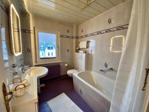 a bathroom with a tub and a sink and a toilet at Ferienwohnung: Villa Eichbaum in Bad Harzburg +15 photos