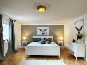 a bedroom with a bed and two tables and a chandelier at Ferienwohnung: Villa Eichbaum in Bad Harzburg