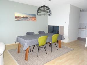 uma mesa de jantar com cadeiras amarelas e uma mesa cinzenta em Kustverhuur, Appartement aan Zee, Prachtig appartement op de begane grond PS 13-001 em Breskens