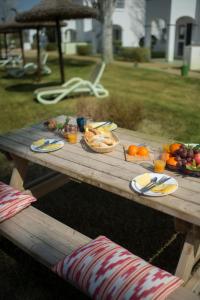 a wooden picnic table with food on top of it at Serenity Apartments in Port d'Alcudia