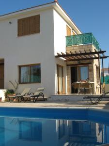 a house with a swimming pool in front of a house at Villa Pergia Latchi in Polis Chrysochous