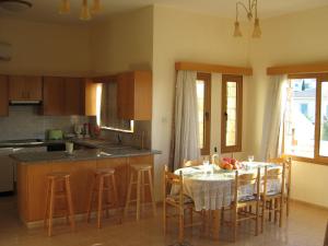 a kitchen with a table and chairs and a kitchen with a table and a kitchen at Villa Pergia Latchi in Polis Chrysochous