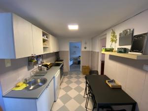 Una pequeña cocina con un fregadero y una mesa. en Mountain Heaven Apartment, en Kolašin